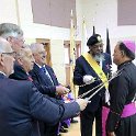 Newly knighted reverend being knighted by dignitaries